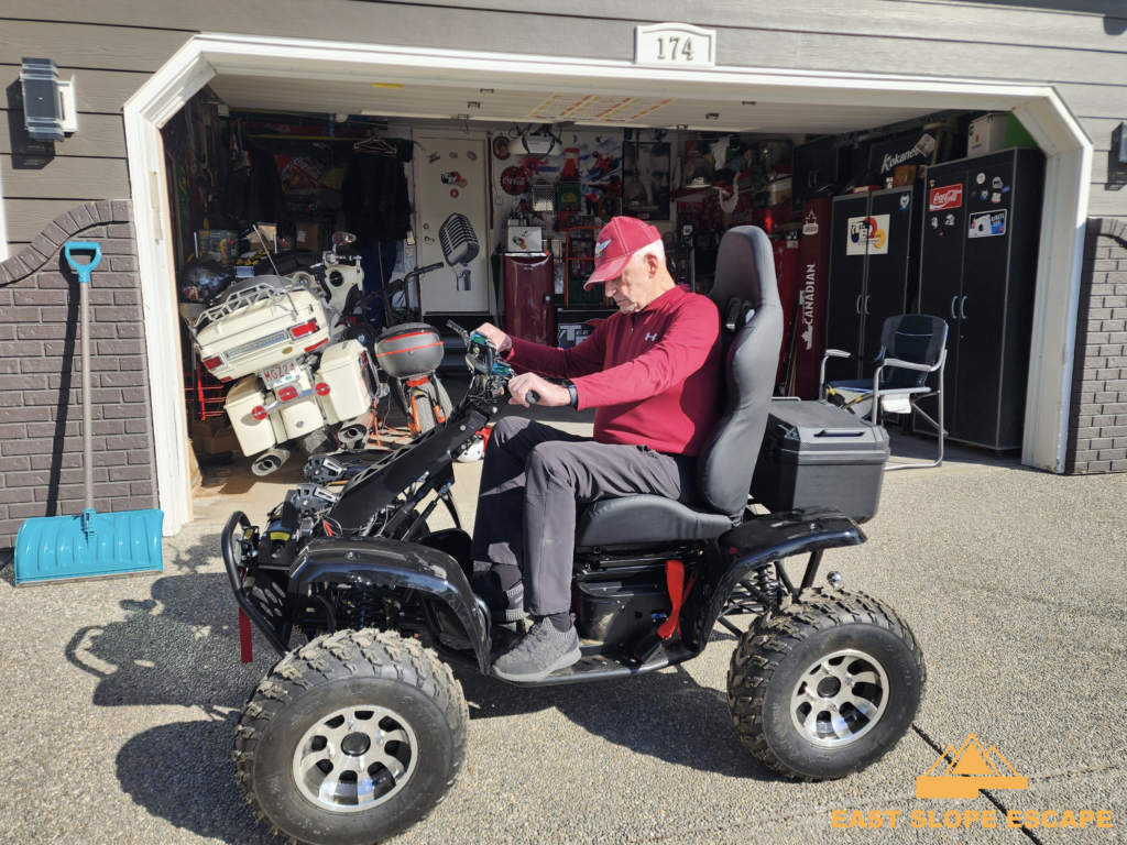 A man sitting on an ATV in his driveway.